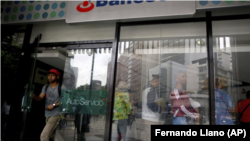 Banesco mientras varios esperan en fila en Caracas, Venezuela, el viernes 4 de mayo de 2018. Venezuela arrestó a 11 altos funcionarios del banco privado más grande del país y anunció que el Estado intervendrá las actividades de la institución por 90 días.