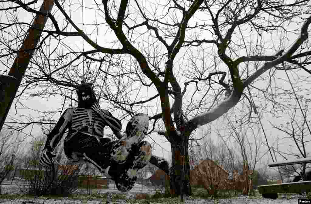 Un juerguista disfrazado de diablo cuelga de un &#225;rbol en la aldea de Valasska Polanka. En el lugar todos los a&#241;os hay un desfile de San Nicol&#225;s, cerca de la ciudad de Vsetin, Rep&#250;blica Checa. [Reuters].