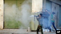 FILE - Libyan soldiers fire their weapons during clashes with Islamic militias in Benghazi, Oct 29, 2014.