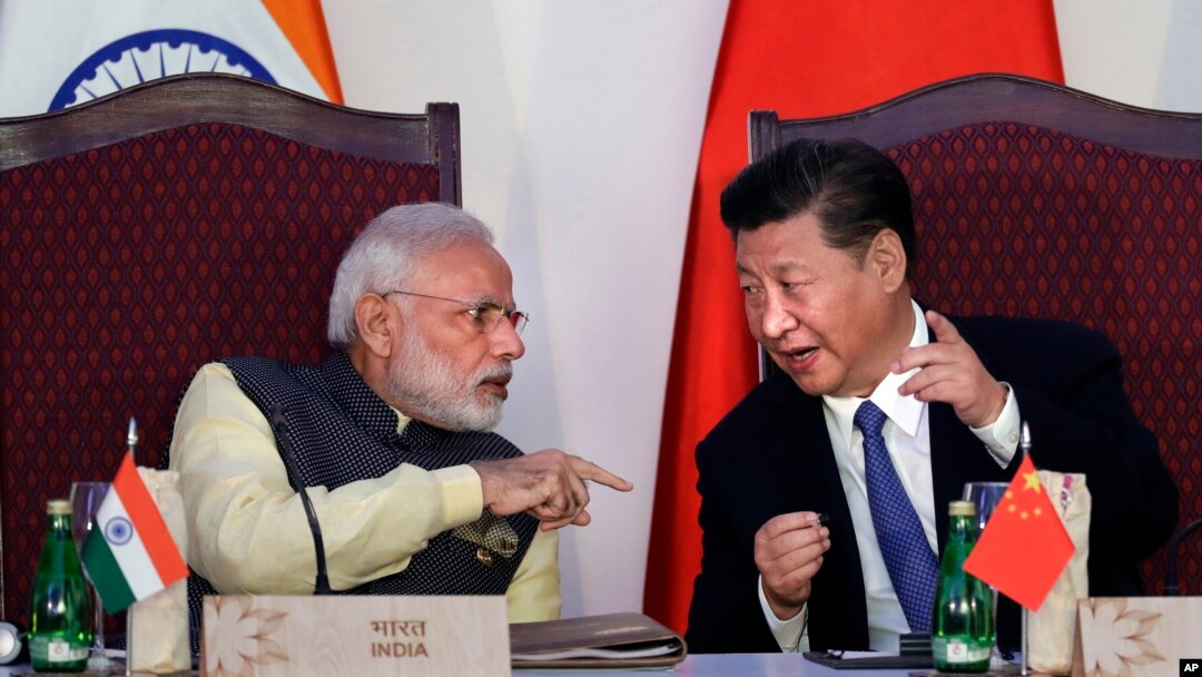  FILE - Indian Prime Minister Narendra Modi, left, talks with Chinese President Xi Jinping at the signing ceremony by foreign ministers during the BRICS summit in Goa, India, Oct. 16, 2016. 