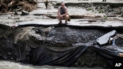 Residentes abrumados examinan los daños causados ​​por las inundaciones causadas por los restos del huracán Beryl, el 11 de julio de 2024, en Plainfield, Vermont.