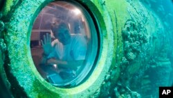 Nhà nghiên cứu Fabien Cousteau vẫy chào từ bên trong chiếc tàu Aquarius 