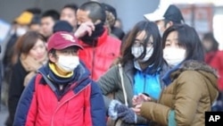 People stand in line at a bus terminal in Sendai, Miyagi prefecture on March 16, 2011.