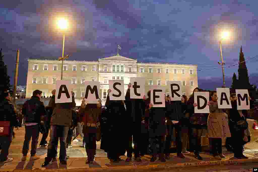 Protesters hold placards spelling the word "Amsterdam" to thank protesters who rallied in other European countries in solidarity with Greek people in front of the parliament in Athens, February 18, 2012. (Reuters)