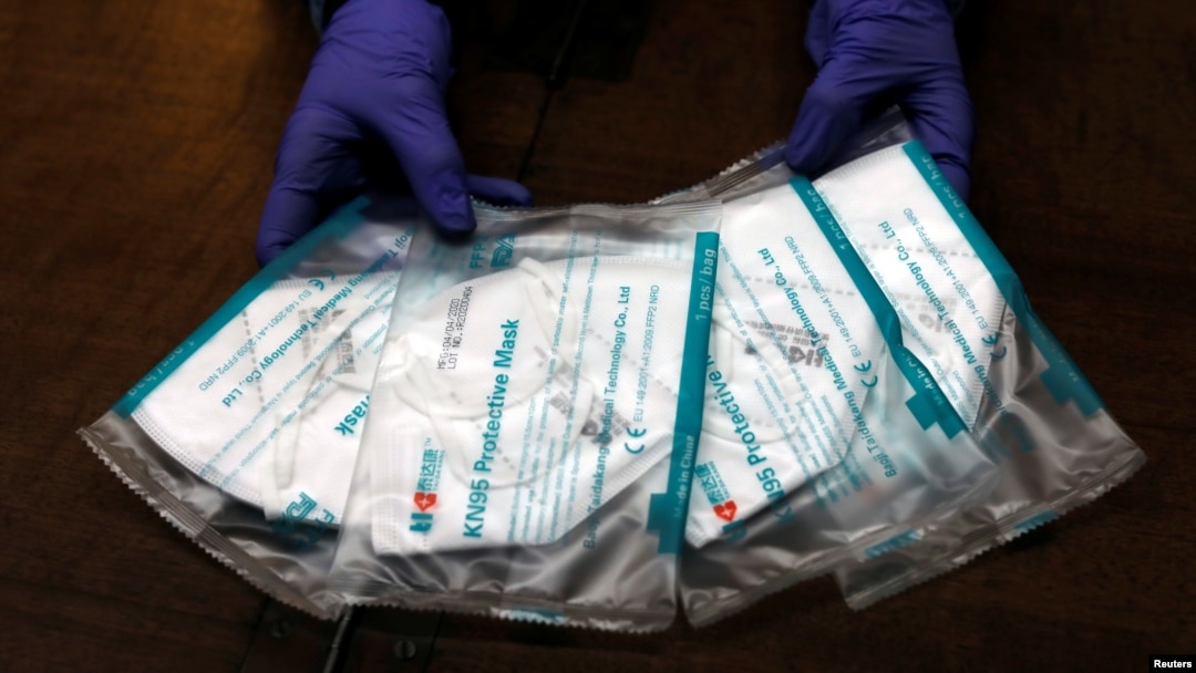 一名药房工作人员在展示KN95防护口罩。(2020年4月16日)