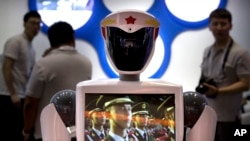 FILE - A video screen plays footage of Chinese People's Liberation Army (PLA) soldiers on a robot from a Chinese robot maker at the World Robot Conference in Beijing, China, Aug. 15, 2018. 