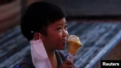 FILE - A child eats an ice cream in Xianning, Hubei province, China March 25, 2020.