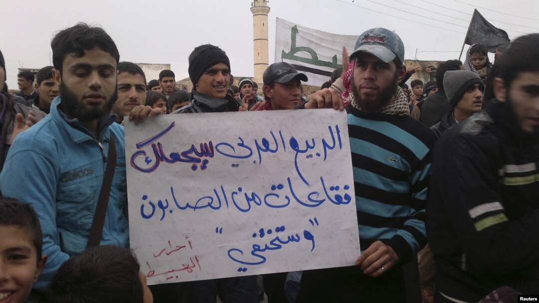 Người Syria cầm biểu ngữ với hàng chữ 'Mùa xuân Ả Rập sẽ biến al-Assad thành bong bóng xà phòng và sẽ biến mất' trong cuộc biểu tình tại Habeet gần Idlib, ngày 6/1/2013. Tại Syria, các nhà báo và người sử dụng internet là nạn nhân của một 'cuộc chiến tranh thông tin' được thực hiện bởi chính phủ Assad.