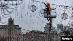 Un trabajador instala luces navideñas sobre una calle, en medio del ataque de Rusia a Ucrania en Kiev, el 4 de diciembre de 2024. REUTERS/Thomas Peter