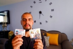 Jesus Lopez, who was deported from the U.S. last year, holds up his Illinois driver's license and a family snapshot, at his home in Zapopan, Jalisco state, Mexico, May 13, 2021. “I belong there," the DACA recipient says of Chicago.