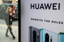 FILE - A pedestrian walks past a Huawei product stand at an EE telecommunications shop in central London, Britain, April 29, 2019.