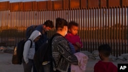 Familias migrantes procedentes de Brasil esperan ser procesadas por los agentes de la Patrulla Fronteriza de Estados Unidos tras cruzar la frontera con México en Yuma, Arizona, el jueves 10 de junio de 2021.