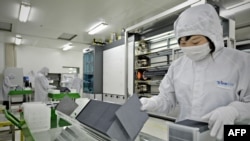 FILE - A worker sorts silicon wafers at the manufacturing center of solar cell maker Trina Solar in Changzhou, China. Trina now has a facility in the Hofusan Industrial Park, about 20 km north of Monterrey, Mexico, not far from the border with Texas.