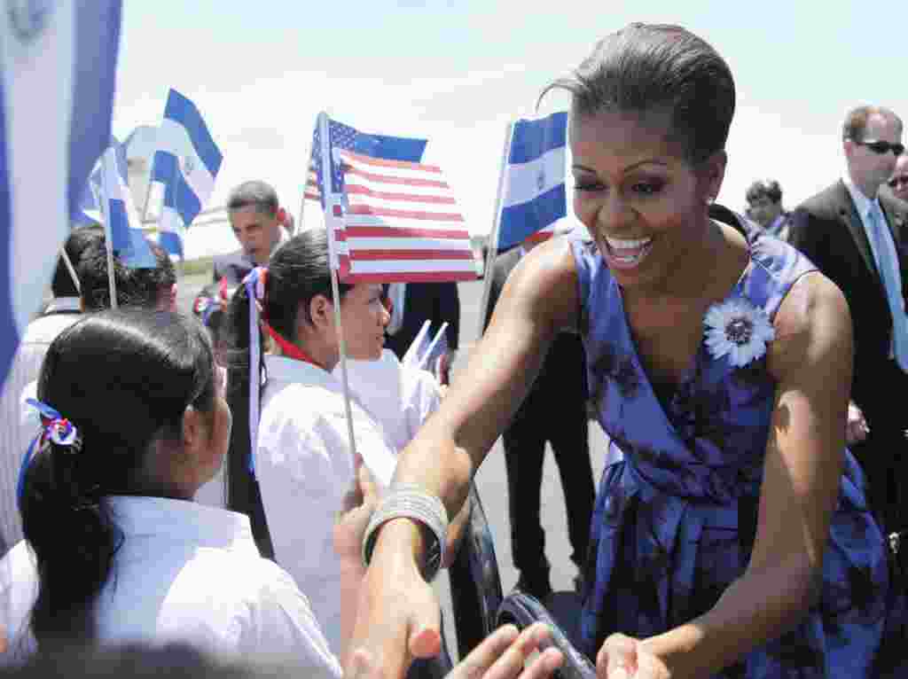 La primera dama de EE.UU., Michelle Obama, y el presidente saludan a los niños salvadoreños a su llegada a ese país.