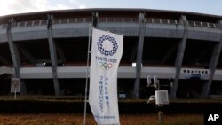 A Tokyo 2020 banner stands in front of the Azuma Baseball Stadium, a venue for baseball and softball at the Tokyo 2020 Olympics, Saturday, Nov. 30, 2019, in Fukushima, Fukushima prefecture, Japan. The torch relay for the Tokyo Olympics will kick off…
