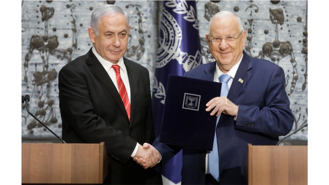 Israeli President Reuven Rivlin, right, shakes hands with Israeli Prime Minister Benjamin Netanyahu in Jerusalem, Sept. 25, 2109.