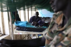 FILE - A child sick from malaria and malnutrition lies on a bed in a hospital in Bor, March 15, 2014.