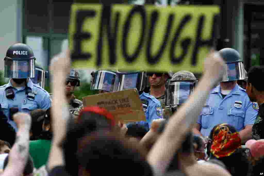 Protesters rally as Philadelphia Police officers and Pennsylvania National Guard soldiers look on, Monday, June 1, 2020, in Philadelphia, over the death of George Floyd, a black man who died in police custody in Minneapolis.