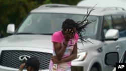 Una niña cubre su rostro del viento y la lluvia producidos por el huracán Ida, el domingo 29 de agosto de 2021, en Nueva Orleans, Estados Unidos.