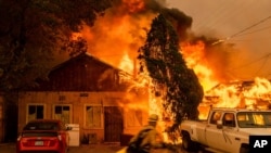 Fire consumes a home as the Sugar Fire, part of the Beckwourth Complex Fire, tears through Doyle, Calif., on Saturday, July 10, 2021. Pushed by heavy winds, the fire came out of the hills and destroyed multiple residences in central Doyle. (AP Photo…