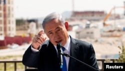 El primer ministro de Israel Benjamin Netanyahu hace declaraciones frente a una nueva construcción en un asentamiento judío al que los israelíes llaman Har Homa y los palestinos Jabal Abu Ghneim, en Cisjordania. 