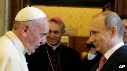 FILE - Pope Francis shakes hands with Russian President Vladimir Putin at the end of their private audience at the Vatican, June 10, 2015.