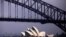 FILE - The sun illuminates the Sydney Opera House as a ferry sails past during a storm at Sydney Harbor in Australia.