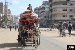 Palestinians transport their belongings as they flee areas north of Gaza City, Oct. 12, 2024.