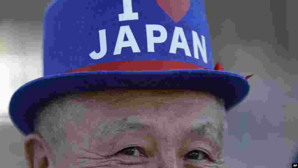 A fan from Japan poses for a picture as he lines up to enter the Maracana Stadium ahead of the opening ceremony for the 2016 Summer Olympics in Rio de Janeiro, Brazil, Aug. 5, 2016. (AP Photo/Natacha Pisarenko)