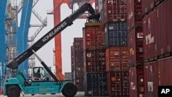 FILE - Seorang petugas mengatur peti kemas di terminal Indonesia Port Corporation di Pelabuhan Tanjung Priok, Jakarta, 8 Oktober 2021. (Tatan Syuflana/AP)