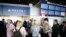 Passengers wait in front of the desk of American airline company 'Delta', at the Roissy Charles de Gaulle airport, north of Paris, March 12, 2020. 