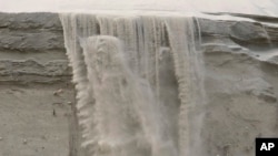 Sand cascades down the badly eroded face of a dune in North Wildwood, New Jersey, on Feb. 24, 2023.