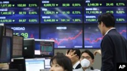 A currency trader wears a face mask at the foreign exchange dealing room of the KEB Hana Bank headquarters in Seoul, South Korea, Feb. 24, 2020. 