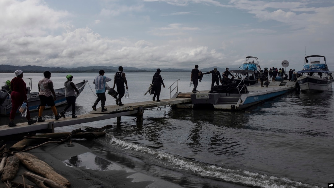ARCHIVO - Migrantes abordan barcos hacia el Tapón del Darién, en Necoclí, Colombia, 7 de octubre de 2023. 