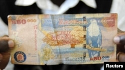 Un homme montre un billet de banque de 50 000 kwachas, la monnaie nationale de la Zambie, à Lusaka le 23 janvier 2012. 