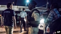 This photo made available by Interpol Monday April 30, 2018 shows Interpol officers during a raid in night clubs in Georgetown, Guyana, on April 7, 2018.