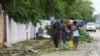 Personas trasladan sus pertenencias mientras el huracán Beryl avanza y se debilita, en Tulum, México, el 5 de julio de 2024.