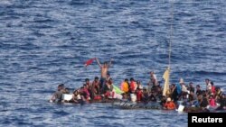 Penumpang sebuah rakit penh penumpang terlihat terombang ambing di selat Makassar (10/6). 