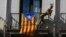 A mannequin stands next to a ''estelada'' or Catalonia independence flag, on a balcony, in Barcelona, Spain, Oct. 23, 2017.