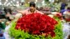 A woman packs a bouquet of 99-rose flowers for the upcoming Valentine's Day on Friday at a market, in Beijing, February 13, 2014. REUTERS/Jason Lee (CHINA - Tags: SOCIETY) - RTX18PYR