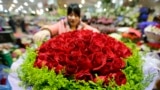 A woman packs a bouquet of 99-rose flowers for the upcoming Valentine's Day on Friday at a market, in Beijing, February 13, 2014. REUTERS/Jason Lee (CHINA - Tags: SOCIETY) - RTX18PYR