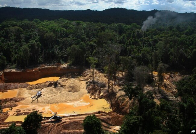 FILE - Helicopters are visible at an illegal mining camp during an operation by Brazil's environmental agency aimed at combating illegal mining in Yanomami Indigenous territory, Roraima state, Brazil, Feb. 11, 2023. (AP Photo/Edmar Barros, File)