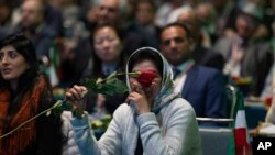 One of the Iranian Americans supporting the National Council of Resistance of Iran holds a single rose at their '2020 LA Convention for Free Iran' at the Los Angeles Convention Center on Saturday, Jan. 11, 2020.