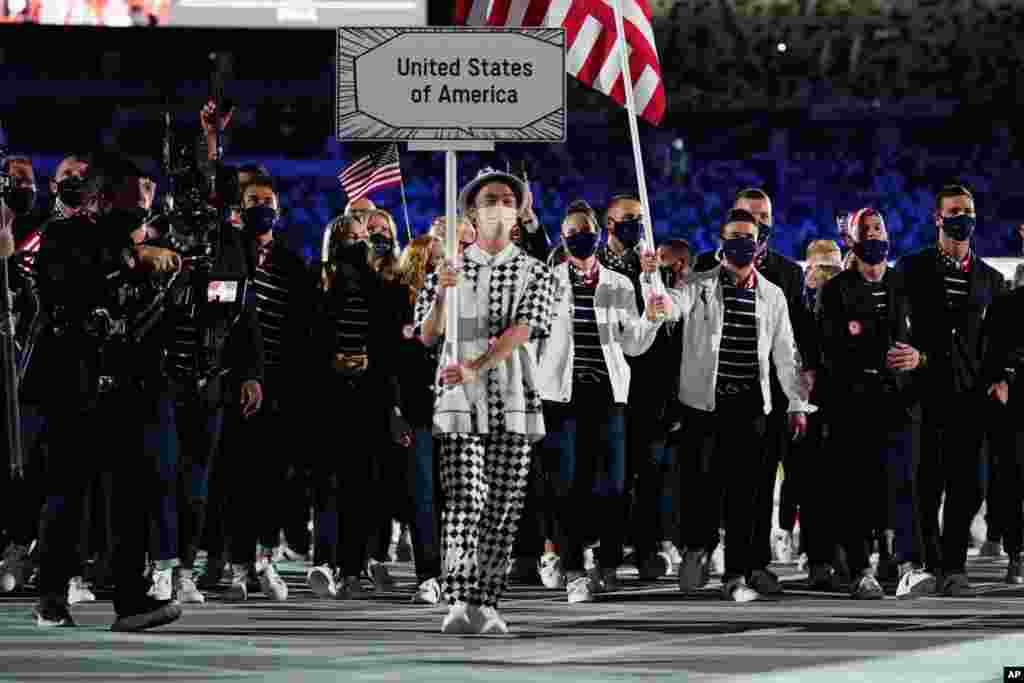 Sue Bird and Eddy Alvares, of the U.S., carry their country&#39;s flag during the opening ceremony in the Olympic Stadium at the 2020 Summer Olympics, July 23, 2021, in Tokyo, Japan.