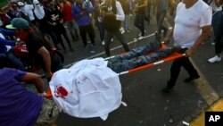 A demonstrator, who was shot in the head and apparently died, is carried by paramedics after clashes erupted during a march against Nicaragua's President Daniel Ortega in Managua, Nicaragua, May 30, 2018.