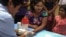 FILE - A public health worker takes a blood sample from a woman to be tested for malaria in Bo Rai district, Trat province, Thailand, Nov. 29, 2017.