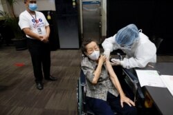 A person receives the first dose of the AstraZeneca COVID-19 vaccine as Thailand starts a mass inoculation at a gymnasium inside the Siam paragon Shopping center, Bangkok, Thailand, June 7, 2021.