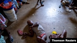 People shelter inside a school after their settlement was burned down by gangs in Port-au-Prince, July 27, 2021.