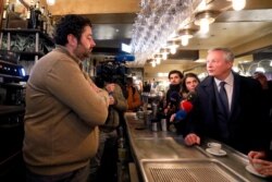 French Finance Minister Bruno Le Maire talks in a cafe as he visits shopkeepers, restaurateurs and hotel operators to assess the economic impact of nationwide strikes on pensions reform in Paris, France, Jan. 3, 2020.