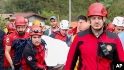 Members of the mountain rescue service carry a body of a person killed by a landslide in the flooded village of Donja Jablanica, Bosnia, Oct. 5, 2024.